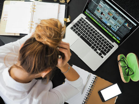 A person standing at a desk while working to stay active during the day